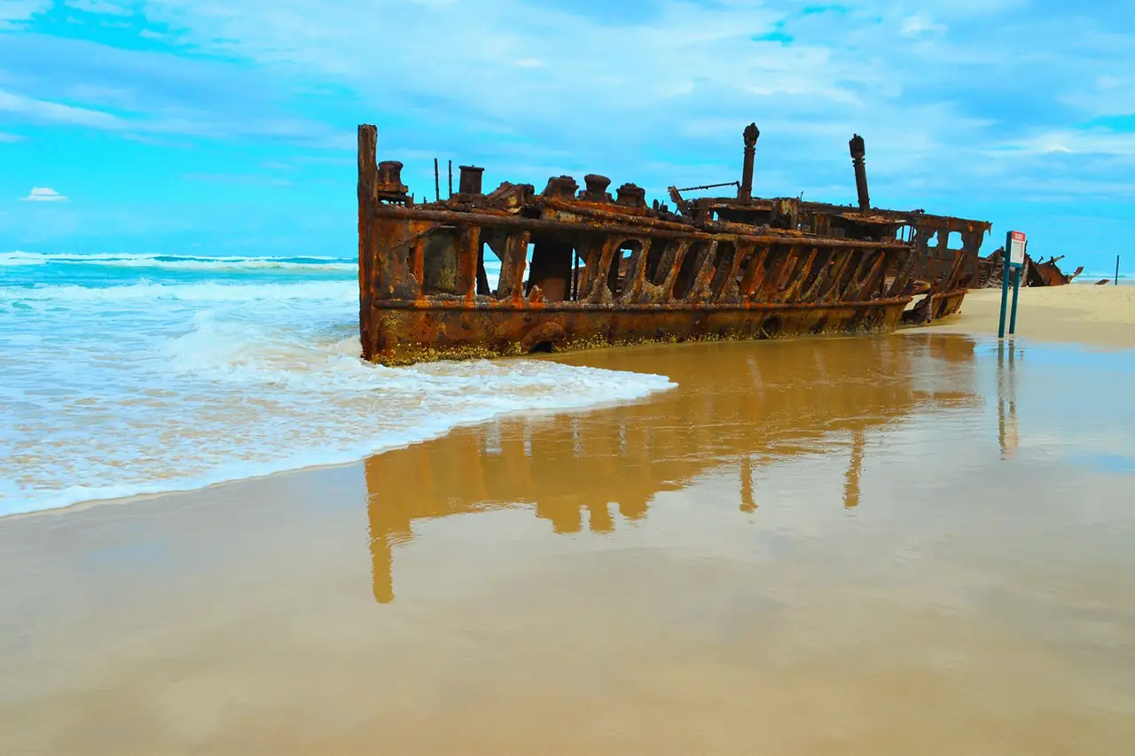 K'Gari (Fraser Island). Shipwrecks with rusted hulls are seen along wind-swept Seventy Five Mile Beach.